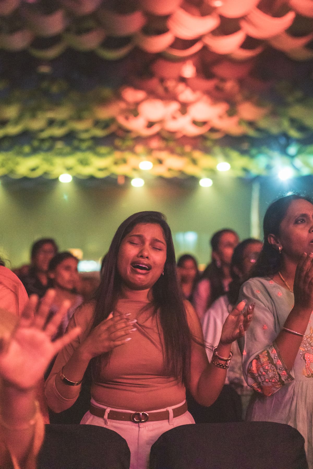 Women worshipping together with hands raised in unity